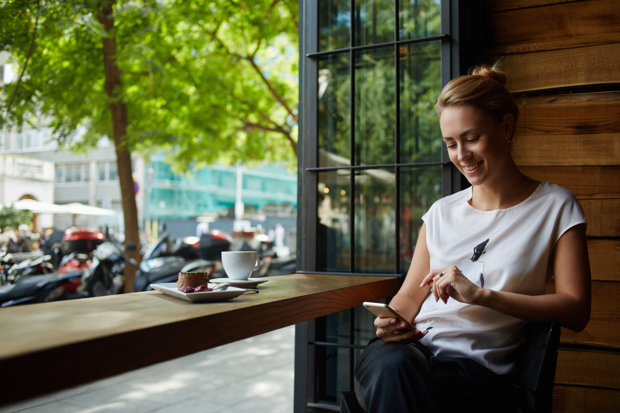 Woman on break looking at phone in coffee shop