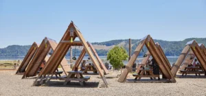 A-frame picnic shelters and outdoor seating at Hama Hama Oyster Saloon overlooking Hood Canal.